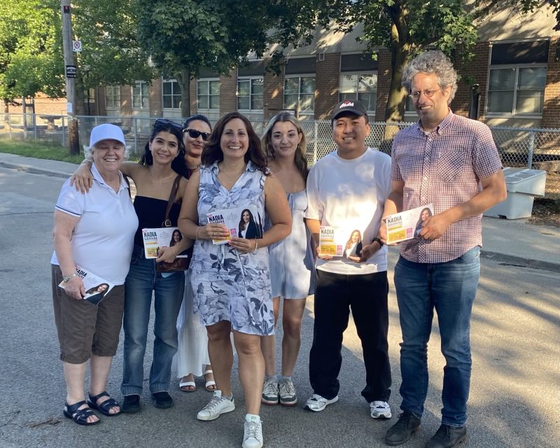 Nadia with canvas group in front of school